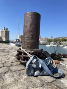 Patch Bag en denim recyclé posé sur le quai du port de La Rochelle