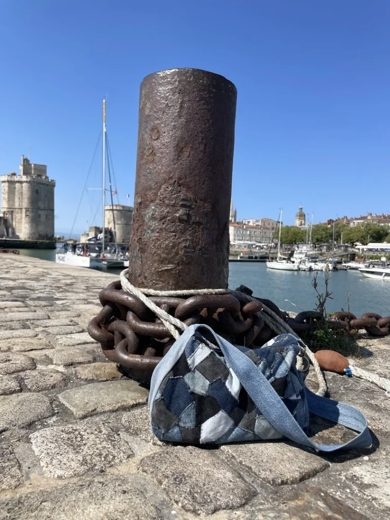 Patch Bag en denim recyclé posé sur le quai du port de La Rochelle