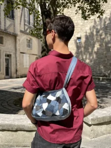 Patch Bag en denim recyclé porté en ville avec une chemise bordeaux